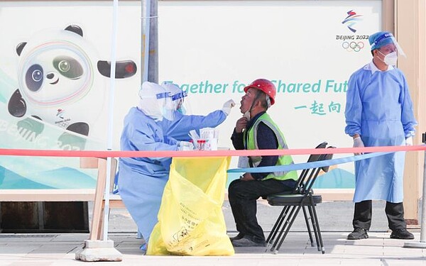 大陸多個城市實施常態化核酸檢測,花費十分巨大。圖為北京市東城區一處核酸檢測點,一名工人接受核酸篩查。圖/中新社