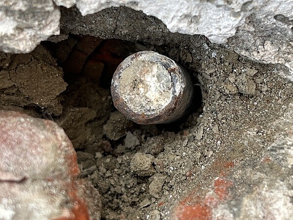 186年歷史的台南佳里善行寺,最近進行屋頂漏水工程搶修,意外在馬背處發現一顆二戰留下來的機槍子彈。圖/文資協會提供