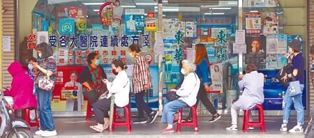 中央疫情指揮中心宣布,超商、藥妝加入配合政府販售快篩試劑,不過9日傳統藥房外面仍然有大批民眾排隊搶購實名制快篩劑,價格較便宜。(季志翔攝)