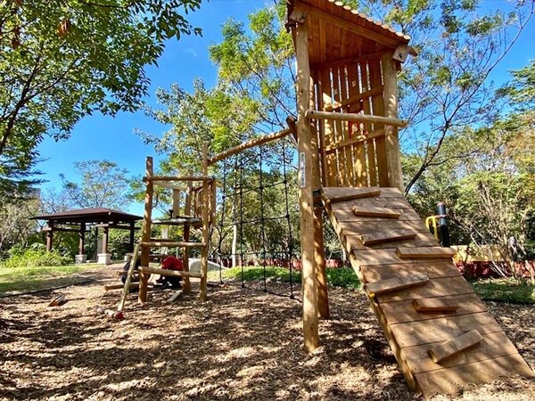 景觀萬坪公園木質遊具跟天然木屑緩衝材，遊戲空間與自然環境融合一起。圖／新北市景觀處提供