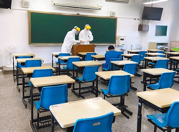 圖為去年國中會考備用試場,發燒考生被安排在第二備用試場應考,監視人員穿著防護衣監考。(教育部提供/林志成台北傳真)