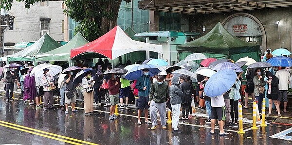 新冠疫情升溫，持陽性快篩試劑等待PCR採檢的人龍，下雨天仍出現在醫院急診室外。記者潘俊宏／攝影