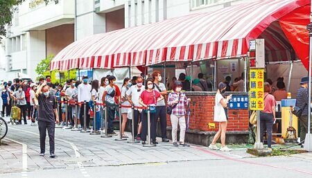 快篩陽視同確診為何不全面實施,指揮官陳時中點出2個不可行的原因。圖為北市聯醫仁愛院區的防疫門診,大批民眾排隊準備看診。(粘耿豪攝)