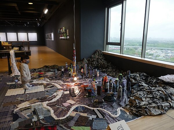 鳳甲美術館當期展覽,藝術家郭奕臣作品「心感地圖」使用航空地景照和工業廢布,重新拼湊出淡水河域的台北。觀眾可使用現場提供的素材,走入地圖中標誌出屬於自己的地方亮點,藉由參與共同完成這幅「心感地圖」。圖/文化局提供