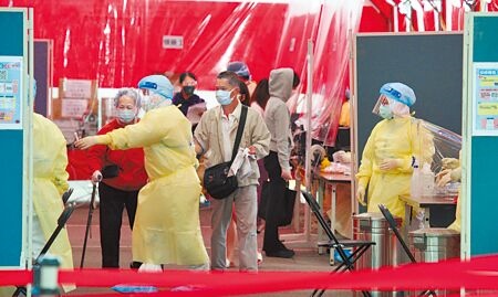 截至目前，國內共累計9例兒童重症個案。圖為台北松山機場三合一大型篩檢站，醫護人員引導長者到指定位置做PCR篩檢。（張鎧乙攝）