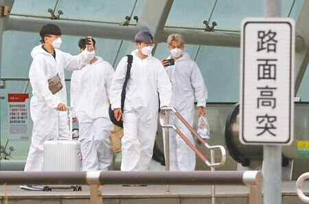 這波疫情爆發後,買快篩要排隊、做PCR要排隊,確診後預約視訊、看診領藥也要排隊,確診者大嘆每一關都卡卡。圖為松山機場篩檢站外,民眾穿著防護衣步離松山機場捷運站。(陳君瑋攝)