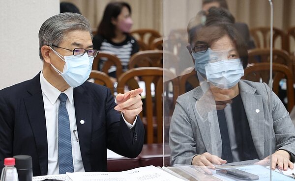 金管會主委黃天牧(左)與保險局長施瓊華(右)上午列席立院財委會針對「防疫保單相關爭議及處理情形」進行專題報告,兩人在會議前私底下交換意見。記者陳正興/攝影