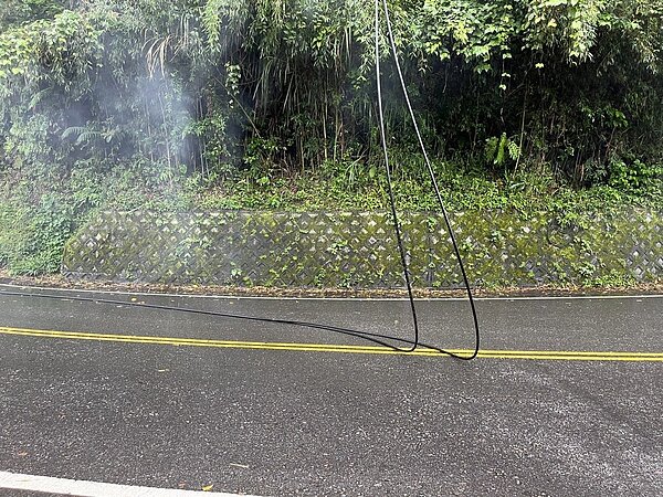 電線脫落後,垂落地面,地面狂冒白煙。記者翁至成/翻攝