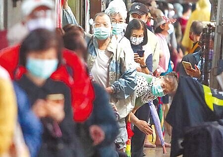 台北市長柯文哲27日指出，北市有25萬人染疫，達總人口數250萬人的10％，代表疫情峰值已過，圖為台北市松山霞海城隍廟27日免費發放新冠肺炎快篩試劑，民眾冒雨排隊等候領取免費試劑。（鄭任南攝）