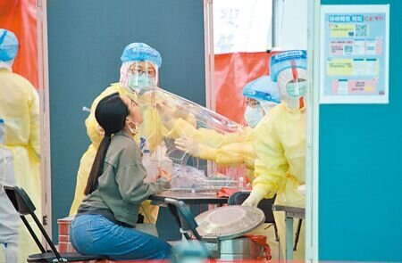 醫師提醒,民眾若是快篩陽要看診,還是先與診所用電話聯繫,避免增加診所感染風險。圖為醫護人員為民眾做PCR篩檢。(張鎧乙攝)