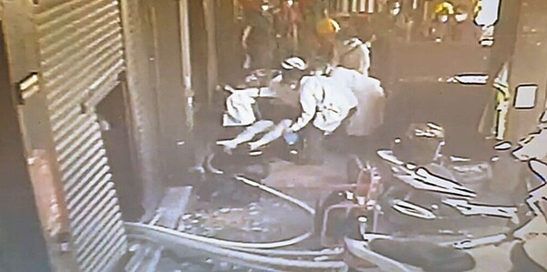 高雄市三民區28日發生住宅大樓失火,救出一對陳姓兄弟,消防員將受困屋內的哥哥救出後,將他抬至擔架,交由救護人員送醫急救。翻攝照片/崔正綱高雄傳真