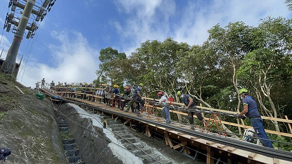 由於纜索不可落地沾到泥土,工作人員協力扛起纜索。圖/台北捷運提供