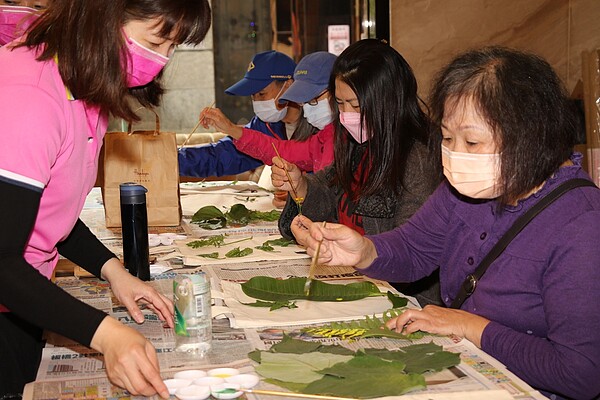 志工老師教導長輩如何用葉脈沾壓克力顏料作畫。圖／新北市政府提供