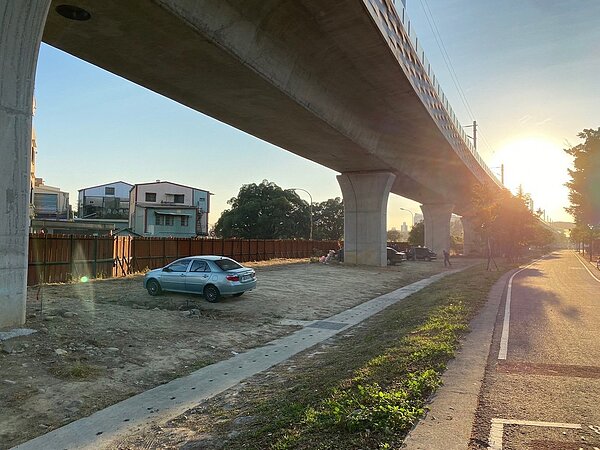 台中鐵路高架化兩側空間打造成綠空廊道,但台鐵局管理的橋下土地雜草叢生,甚至被亂停車。圖/立委黃國書服務處提供
