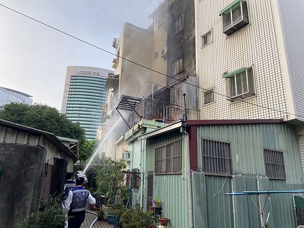 高雄市前鎮區昆明街透天樓房後房起火,消防隊正滅火中。記者林保光/翻攝