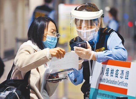 昨驗出3例境外移入Omicron個案,圖為桃機防疫人員協助旅客登錄檢疫資料。(范揚光攝)(圖中非新聞當事人)