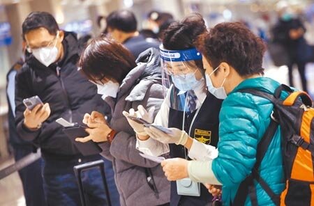 衛福部長陳時中表示,新冠疫情發展於明年春節後應會更明朗化。圖為桃園機場人員協助旅客登錄入境檢疫資料。(范揚光攝)