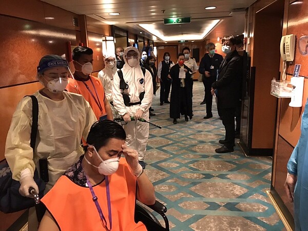 模擬船上醫療人員將疑似症狀之個案送負壓隔房,沿途路徑消毒。圖/航港局提供