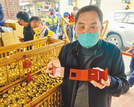 紫南宮主委莊秋安，展示今年加碼的「金雞蛋」獎品金戒指。（廖志晃攝）