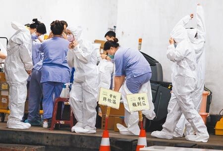 負責清潔桃園機場的承包商一名清潔人員傳出確診,承包商業者在下午也將負責清潔的員工全數採檢,採檢人員在工作開始前穿上防護衣全副武裝。(陳麒全攝)