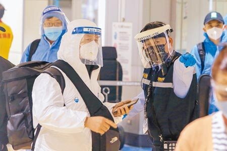 國際新冠疫情嚴峻,台灣疫情近來也明顯升溫,桃園機場入境旅客全副武裝,不敢大意。(陳麒全攝)