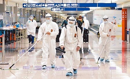 Omicron突破邊境防線,桃機清潔人員在旅客走過的路徑加強清消。(陳麒全攝)