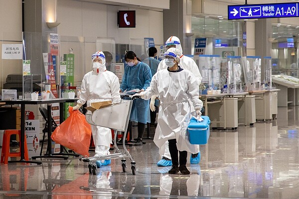 為避免醫院收治大量入境確診患者,恐導致醫療量能崩潰,衛福部祭出三大措施,舒緩醫療量能。圖為今晨航班旅客採檢的檢體由醫事人員送驗。記者季相儒/攝影