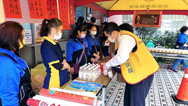 永慶房屋協助里長舉辦臘八粥活動，分配礦泉水和平安粥給里民。圖／永慶房產集團提供	