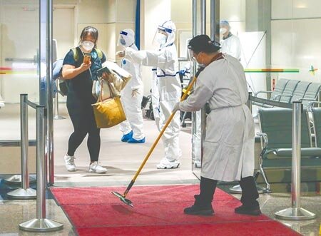 桃園機場依風險不同，要求員工穿著不同防護裝備，風險高者著「兔寶寶裝」，風險低者則穿防水隔離衣。（陳麒全攝）