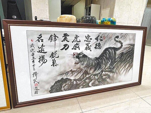 刑事局偵破以曹姓男子為首的靈骨塔詐欺集團,曹具北聯幫黑道身分,警方查出至少10人受騙,財損逾2000萬。圖為警方查扣象徵北聯幫精神的老虎字畫等證物。(警方提供/胡欣男台北傳真)