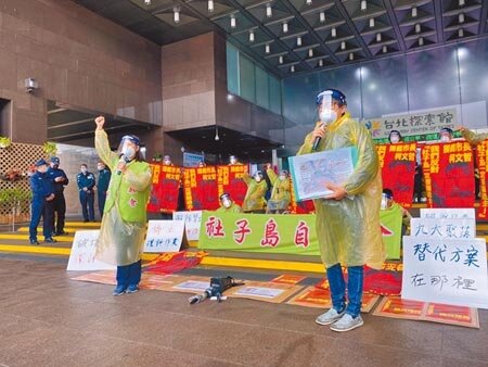 社子島自救會居民昨穿戴N95口罩、護目鏡等個人防護裝備在北市府前抗議高喊,「不顧疫情強開環評、離譜環評立即停止」。(游念育攝)