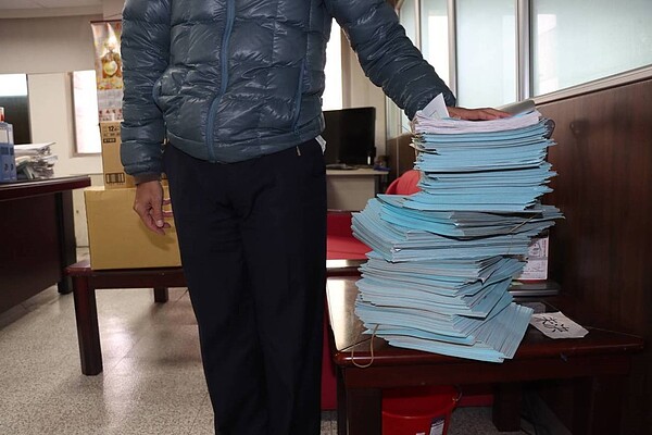 彰化市一輛被註銷的小貨車充當路霸,持續占用中民街公有路邊停車格賣水果達3年,警方幾乎每天都前往開單,累計開罰達1千多次,堆到半人高,總滯欠金額達37萬9384元。圖/彰化行政執行署提供