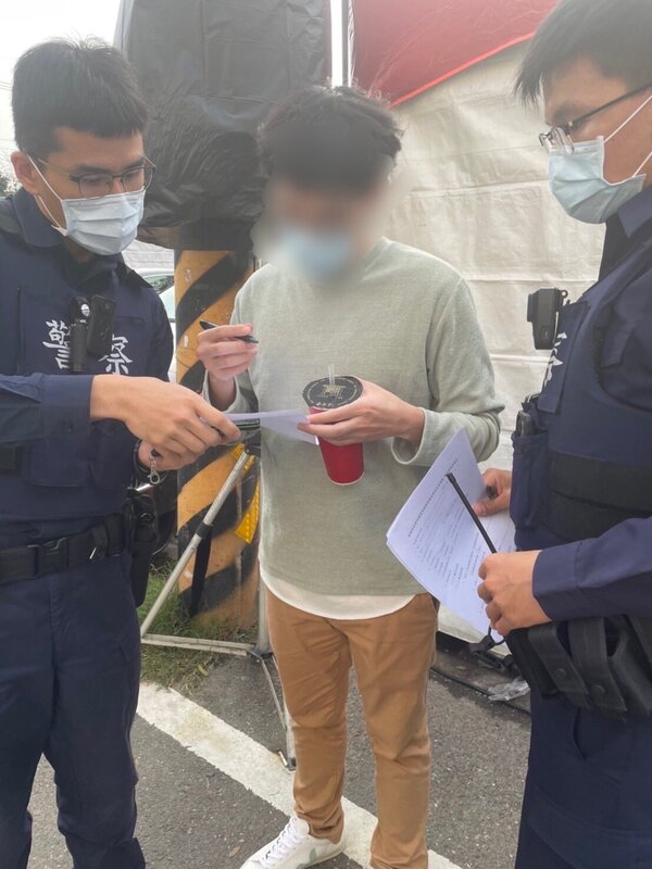 台南市政府23日在新化年貨大街查獲一名男子脫下口罩邊走邊吃，當場開出3000元罰單。圖／衛生局提供