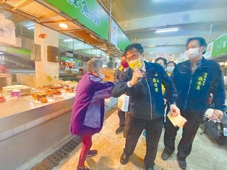 台南市長黃偉哲(中)30日視察歸仁傳統市場防疫,前來市場採買的阿嬤對防疫也很有概念,以手肘碰市長手肘,避開握手。(曹婷婷攝)