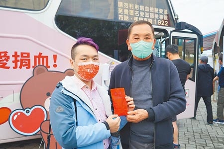 搶到頭香是來自台北的邱先生（左），凌晨3點就從台北開車南下，第一個捐完血獲得紫南宮主委莊秋安（右）親自頒贈金銀錢母。（吳建輝攝）