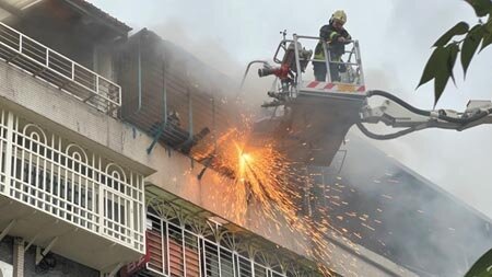 新北市新莊區自立街公寓民宅10日下午5時許傳出火警，蔡姓男子受困5樓陽台鐵窗，消防員獲報後破門搶救，蔡男在窗邊已成焦屍，詳細起火原因仍待調查。（戴上容攝）