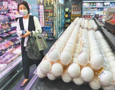 全台鬧蛋荒，不僅貴而且還缺貨，農委會主委陳吉仲11日宣布批發價再漲2元。圖為民眾在超市選購雞蛋。（季志翔攝）