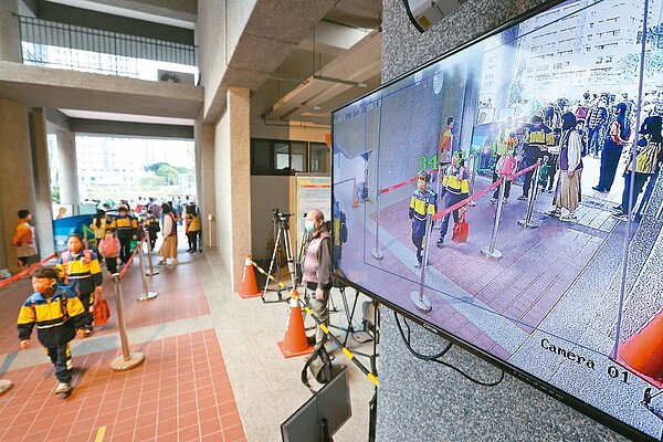 指揮中心分析,兒童染Omicron,六成三有發燒症狀。圖為昨天開學日,新北市板橋中山國小學童通過體溫量測後,魚貫進入校園。記者林澔一/攝影