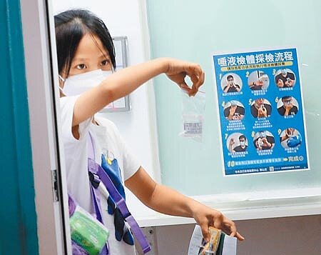 台北醫學大學附設醫院胸腔內科醫師周百謙表示,機艙內溼度低,旅客下機時經常會想喝水,但這個動作會沖淡唾液中的病毒濃度,如果Ct值剛好在臨界點,只要喝一口水就可能因此沒驗出來,會有漏網之魚。桃園機場第二航廈外的採檢站,1名剛入境的旅客準備將唾液檢體交給防疫人員。(范揚光攝)