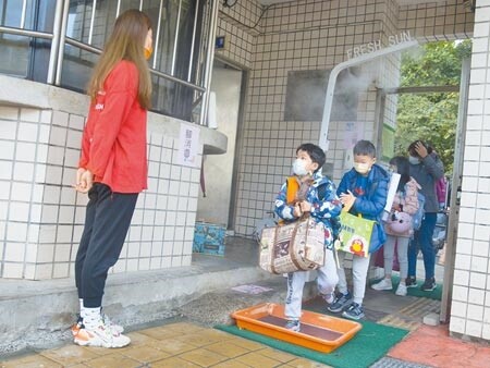 台北市大佳國小日前迎來開學日，為因應疫情，大佳國小在校門口設置擁有奈米5防護的噴霧式消毒機，而小朋友除了量測體溫及消毒手部外，還要消毒鞋底才能走進校門。（杜宜諳攝）