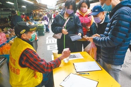 
新北市昨增7例確診，林口國中、麗園國小2校即日起至25日全校預防性停課14天、採線上教學。圖為新北市民治市場在3處主要出入口設管制點，落實實聯制、手部消毒、戴口罩、量體溫等基本防疫措施。（鄧博仁攝）
