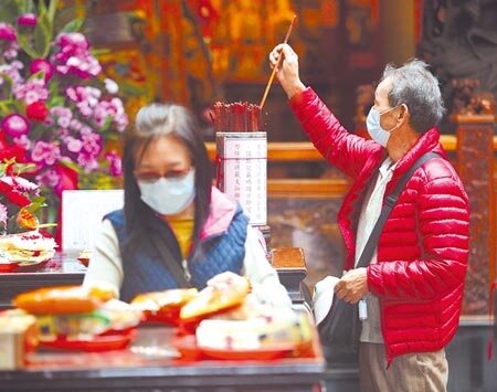 本土疫情未再擴大,疫情指揮中心16日起放寬宗教場所相關限制,接下來就是放寬邊境管制的考驗。圖為民眾在關渡宮拜拜求籤。(張鎧乙攝)