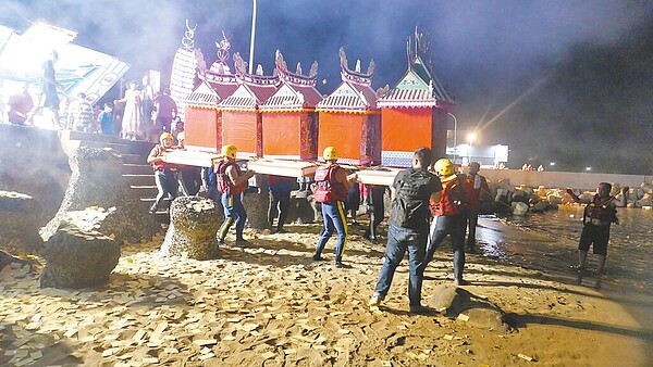 金山區中元節放水燈是由在地義消合力抬著屋型水燈到水尾漁港施放。(金山區公所提供/王揚傑新北傳真)