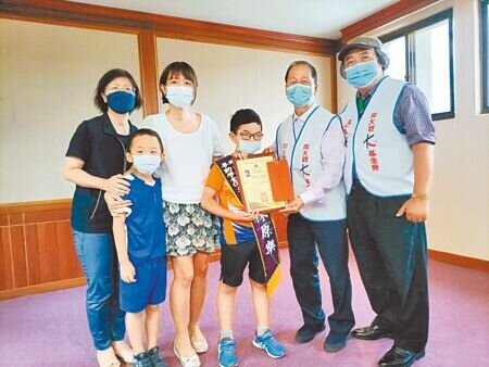 
周大觀文教基金會「抗癌圓夢助學金」活動15日舉行，腦癌小鬥士陳原樂（中)挺身受獎。（陳淑娥攝）
