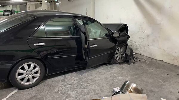 住戶開車進地下室停車突失控撞牆1死1傷,車頭全毀,警方採證調查。記者游明煌/翻攝