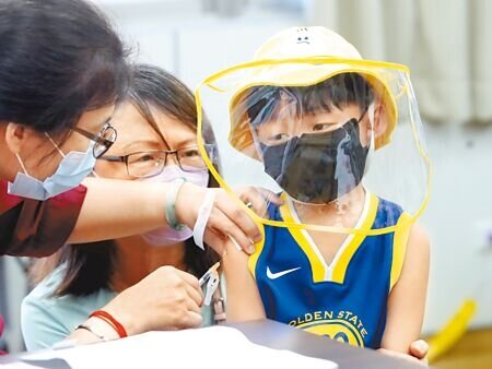 在北市婦幼醫院的新冠肺炎疫苗接種站一位小朋友在家人的陪伴下,忍住疼痛接受疫苗接種。(鄭任南攝)