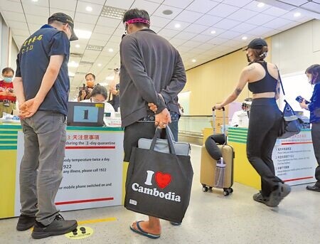 被騙至柬埔寨的18歲鄭姓男子,21日下午搭機回台,同行還有一名張姓關係人,張男手提印有「我愛柬埔寨」英文字樣的提袋,顯得諷刺。(陳麒全攝)
