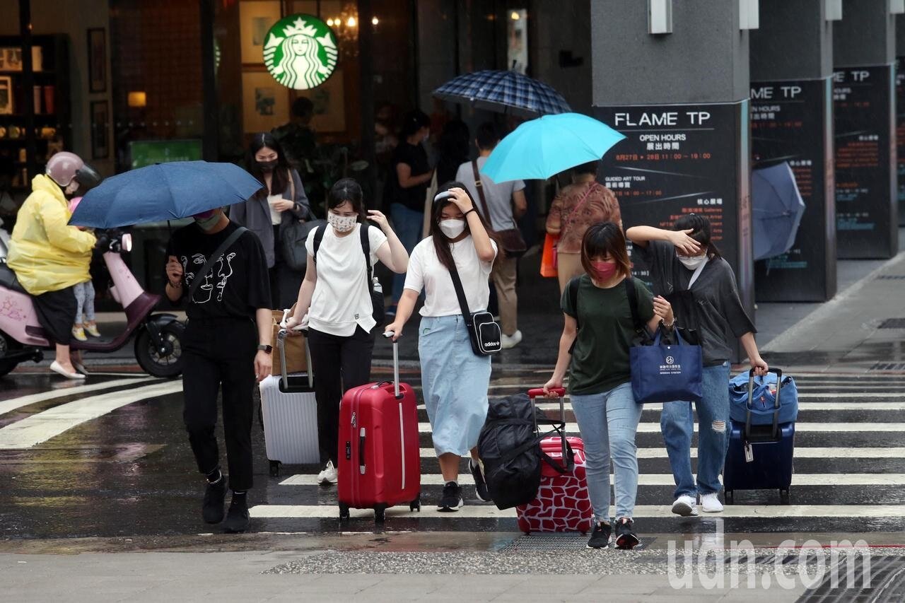中央氣象局發布台北市、新北市、桃園市山區、新竹縣山區、南投縣山區、宜蘭縣山區大雨特報，台北市中心下午也下起陣雨來，雖然不大，但也讓沒有防備的民眾淋了身溼，匆匆忙忙以手遮頭、拉著行李過馬路。記者邱德祥／攝影 