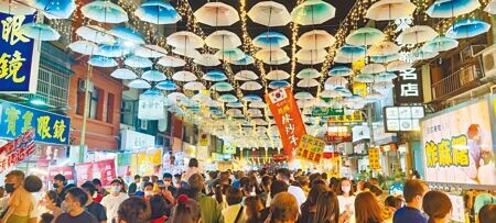 苑裡鎮鬼門關夜市26日晚間登場，鎮公所特別安排馬卡龍色系傘陣布成裝置藝術，更添《神隱少女》中鬼市的神祕氣氛。（謝明俊攝）