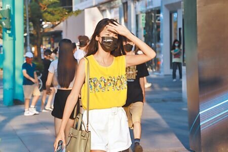 中央氣象局指出,台灣在太平洋高壓邊緣,天氣炎熱高溫飆至37、38度,提醒民眾注意防曬、防中暑。夏日午後,民眾至信義街頭逛街,以手遮擋頭上刺眼陽光。(實習攝影記者謝家瑀攝)